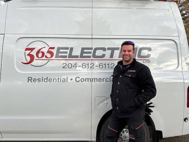 Andrew Milinkovic, owner of 365 Electric, standing beside a 365 Electric service van