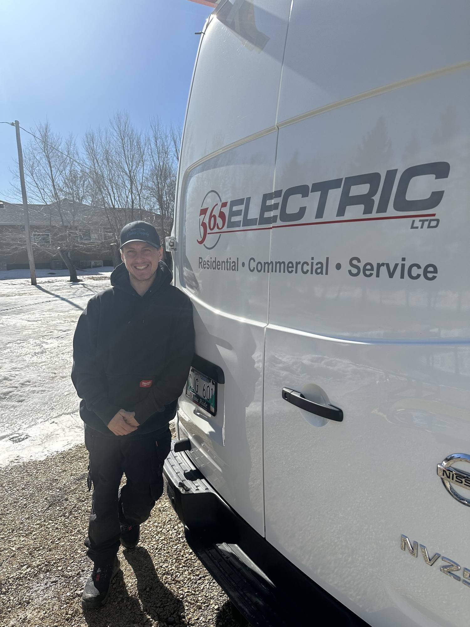 Kyle Holubowich, 365 Electric electrician, standing beside a 365 Electric service van