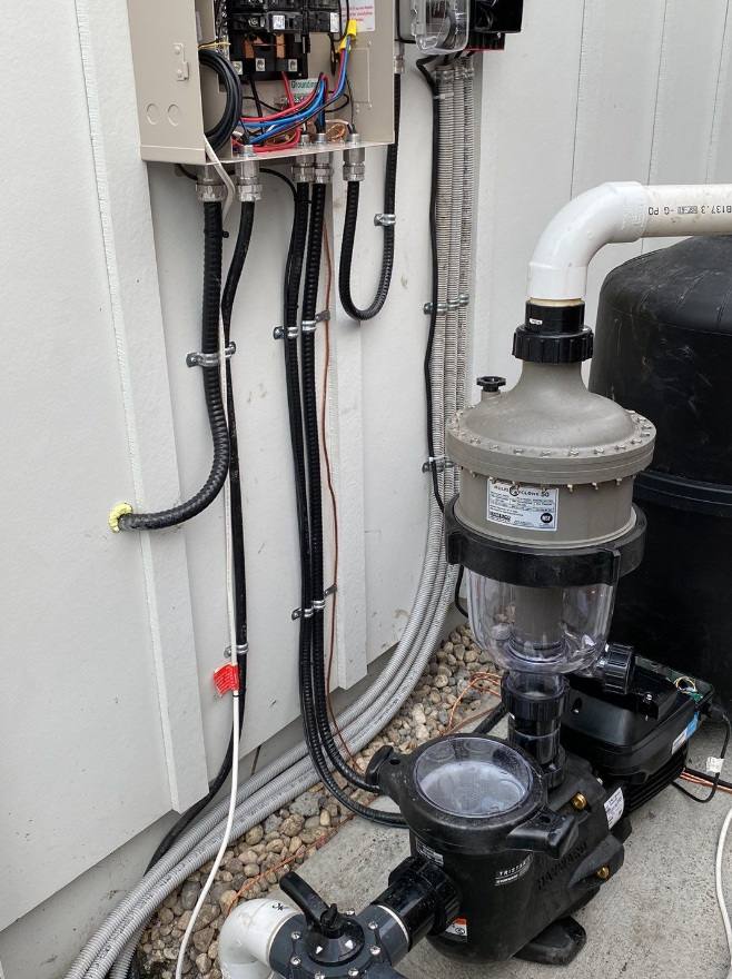 Pool pump and filter wired from a wall-mounted electrical enclosure with liquid-tight flexible conduit