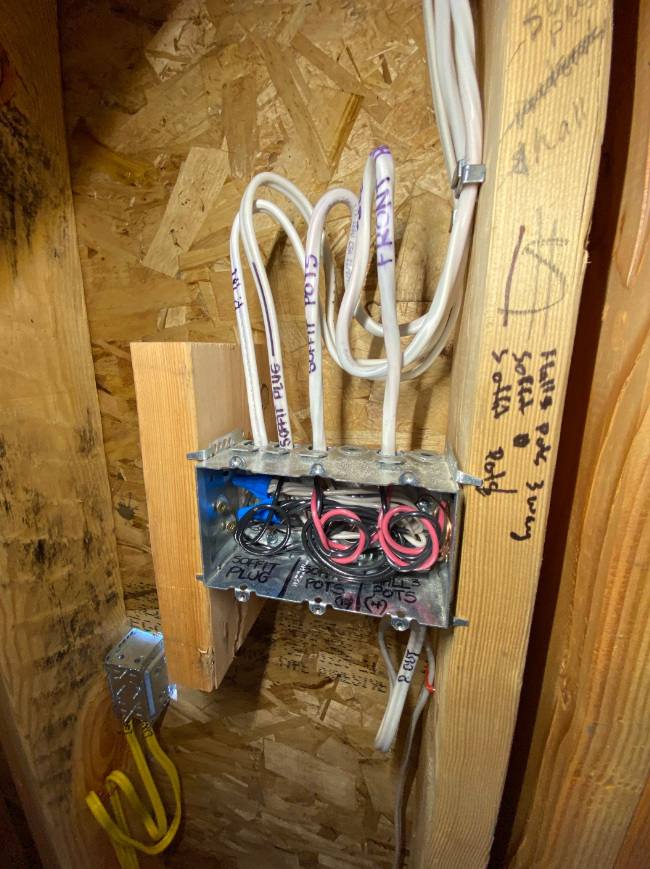 Rough-in wiring with labelled cables entering a multi-gang box in a framed wall
